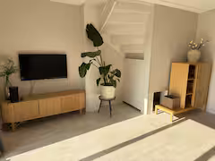 Woonkamer met televisie en trap